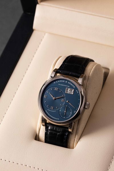 LANGE & SOHNE - Lange 1 ref 191.028 in oro bianco carica manuale con fondello a vista, datario e indicazione della riserva di carica e piccoli secondi con raro quadrante blu.<BR>Accompagnato da scatola originale e garanzia  - Asta Orologi da Polso e da Tasca - Associazione Nazionale - Case d'Asta italiane