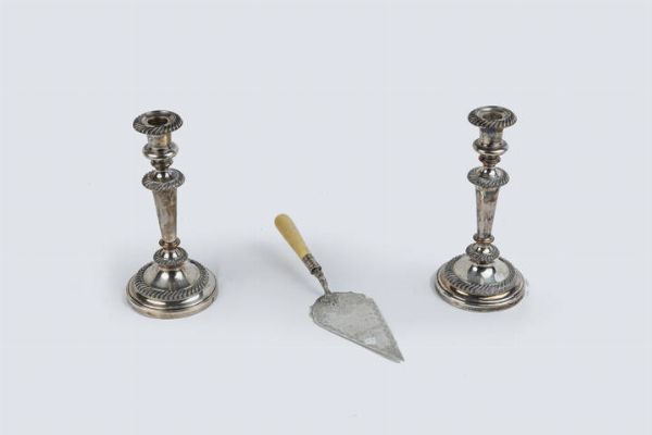 LOTTO DI TRE OGGETTI IN ARGENTO : Composto da: - 1 coppia di candelieri a una sola luce con basi in resina. Peso lordo gr 2124 4 - 1 cazzuola. Peso lordo gr 224 6  - Asta Antiquariato, Argenti, Dipinti e Sculture - Associazione Nazionale - Case d'Asta italiane