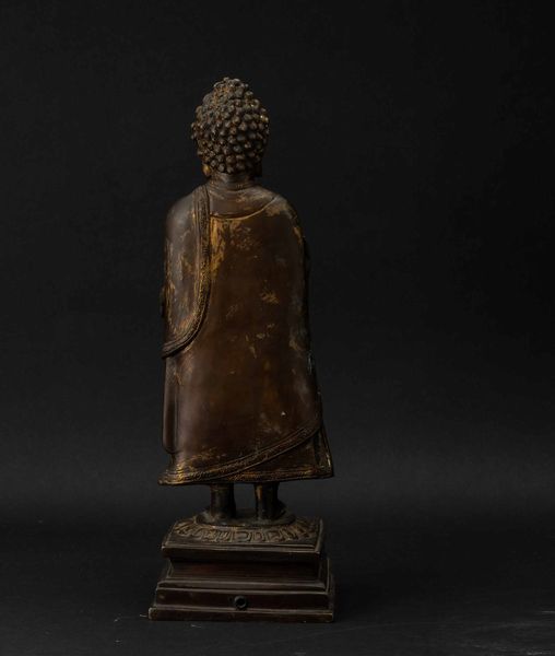 Figura di Buddha stante su fiore di loto in bronzo con tracce di doratura, Cina, Dinastia Qing, XVII secolo  - Asta Fine chinese works of art - Associazione Nazionale - Case d'Asta italiane