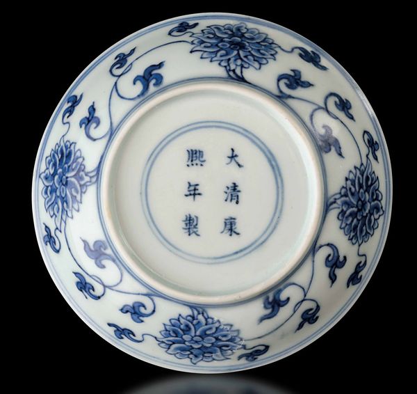 Piccolo piatto in porcellana bianca e blu con decoro a fiori di loto, Cina, Dinastia Qing, marca e del periodo Kangxi (1662-1722)  - Asta Fine chinese works of art - Associazione Nazionale - Case d'Asta italiane