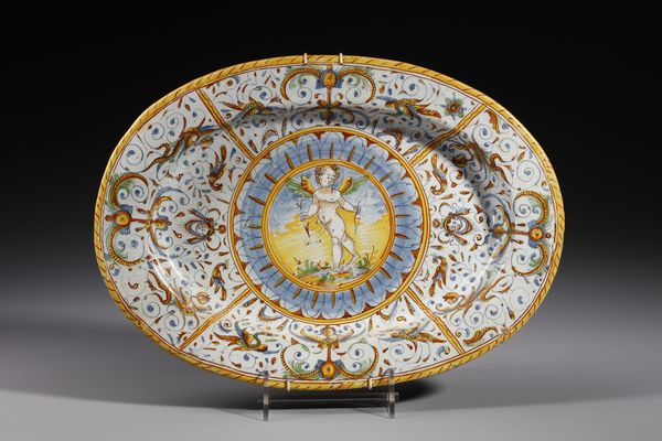 MANIFATTURA DI DERUTA : Piatto ovale in maiolica policroma decorato con putto alato armato di arco entro medaglione circolare contornato da decori a raffaellesche  - Asta Asta 379 | ARTE ANTICA E DEL XIX SECOLO - Dipinti antichi e antiquariato  Online - Associazione Nazionale - Case d'Asta italiane