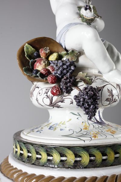 MANIFATTURA BARETTONI, NOVE, INIZI DEL XX SECOLO : Attribuito a. Grande vaso in ceramica dipinta con decorazioni di fiori e frutti e paesaggio naturale con volatili nella parte centrale, sormontato da figura di putto che mangia l'uva  - Asta Asta 379 | ARTE ANTICA E DEL XIX SECOLO - Dipinti antichi e antiquariato  Online - Associazione Nazionale - Case d'Asta italiane