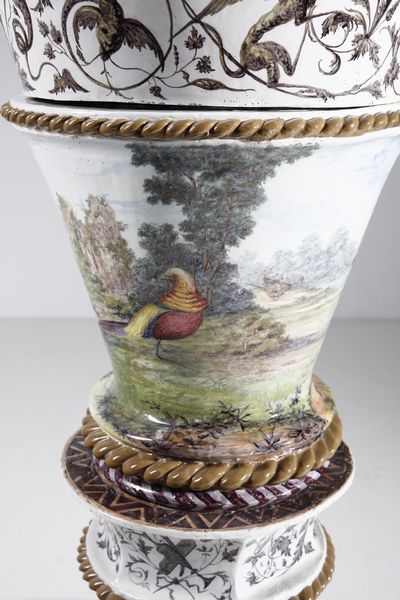 MANIFATTURA BARETTONI, NOVE, INIZI DEL XX SECOLO : Attribuito a. Grande vaso in ceramica dipinta con decorazioni di fiori e frutti e paesaggio naturale con volatili nella parte centrale, sormontato da figura di putto che mangia l'uva  - Asta Asta 379 | ARTE ANTICA E DEL XIX SECOLO - Dipinti antichi e antiquariato  Online - Associazione Nazionale - Case d'Asta italiane