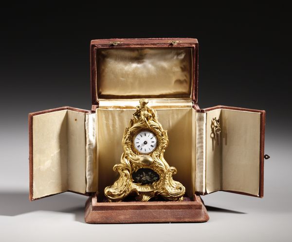 MANIFATTURA FRANCESE DEL XIX SECOLO : Piccolo orologio da tavolo in bronzo dorato in stile Luigi XV, ornato da volute e decorazioni floreali, sormontato da una figura di putto  - Asta Asta 379 | ARTE ANTICA E DEL XIX SECOLO - Dipinti antichi e antiquariato  Online - Associazione Nazionale - Case d'Asta italiane