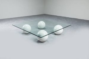 PRODUZIONE ITALIANA - Tavolino con elementi di sostegno in marmo  piano in vetro molato. Anni '70 cm 26x110x110