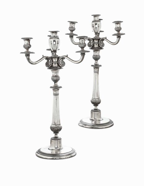 Coppia di candelabri a tre bracci in argento fuso, sbalzato e cesellato. Genova XIX secolo, bollo con delfino e bollo di titolo (aquila coronata con lo stemma di Savoia sul petto). Argentiere AS (non identificato)  - Asta L'art de la table - Associazione Nazionale - Case d'Asta italiane