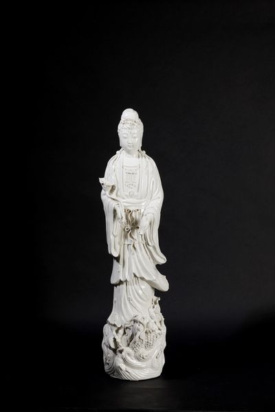 Figura in porcellana Blanc de Chine raffigurante Guanyin eretta su con vasetto, ramo fiorito e drago sulla base, Cina, inizi XX secolo  - Asta Arte Orientale - Associazione Nazionale - Case d'Asta italiane