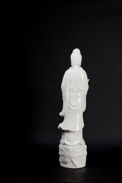 Figura in porcellana Blanc de Chine raffigurante Guanyin eretta su con vasetto, ramo fiorito e drago sulla base, Cina, inizi XX secolo  - Asta Arte Orientale - Associazione Nazionale - Case d'Asta italiane