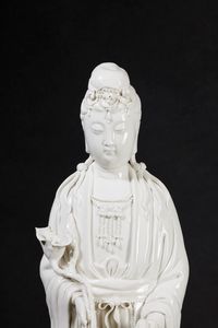 Figura in porcellana Blanc de Chine raffigurante Guanyin eretta su con vasetto, ramo fiorito e drago sulla base, Cina, inizi XX secolo  - Asta Arte Orientale - Associazione Nazionale - Case d'Asta italiane