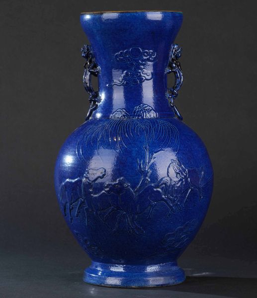 Vaso in porcellana monocroma blu con anse sagomate a foggia di drago e raffigutazioni di cavalli a rilievo, Cina, Dinastia Qing, XIX secolo  - Asta Arte orientale - Associazione Nazionale - Case d'Asta italiane