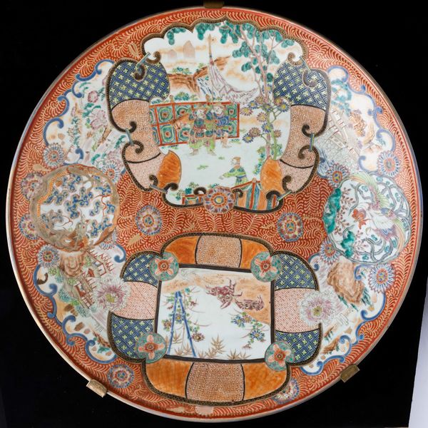 Grande piatto in porcellana Imari con figure di guerrieri e soggetti naturalistici entro riserve sagomate, Giappone, XIX secolo  - Asta Arte orientale - Associazione Nazionale - Case d'Asta italiane