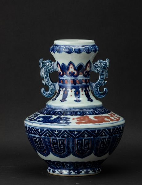 Vaso in porcellana con anse sagomate e decoro dispirazione arcaica nei toni del blu e del rosso ferro, Cina, Dinastia Qing, XIX secolo  - Asta Arte orientale - Associazione Nazionale - Case d'Asta italiane