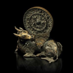 Portaspecchio in bronzo parzialmente dorato a forma di bufalo e placca da specchio con decori a rilievo, Cina, Dinastia Tang (618-906)/Dinastia Ming (XVII secolo)  - Asta Fine Chinese Works of Art - Associazione Nazionale - Case d'Asta italiane