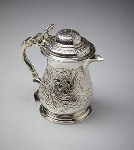 ARGENTIERE INGLESE DEL XIX SECOLO : Tankard in argento con coperchio, corpo piriforme con decorazioni fitomorfe e a volute e stemma nobiliare sul fronte  - Asta Asta 401 | ARTE ANTICA E DEL XIX SECOLO Online - Associazione Nazionale - Case d'Asta italiane