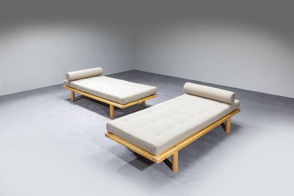 CHARLOTTE PERRIAND  nello stile di : Coppia di Daybed con struttura in legno e cuscini imbottiti rivestiti in tessuto. Anni '70 cm 56x190x84  - Asta Design - Associazione Nazionale - Case d'Asta italiane