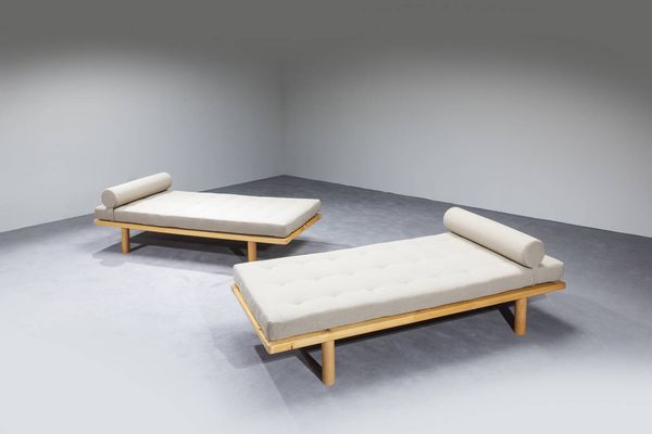 CHARLOTTE PERRIAND  nello stile di : Coppia di Daybed con struttura in legno e cuscini imbottiti rivestiti in tessuto. Anni '70 cm 56x190x84  - Asta Design - Associazione Nazionale - Case d'Asta italiane