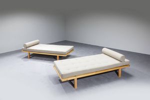 CHARLOTTE PERRIAND  nello stile di : Coppia di Daybed con struttura in legno e cuscini imbottiti rivestiti in tessuto. Anni '70 cm 56x190x84  - Asta Design - Associazione Nazionale - Case d'Asta italiane