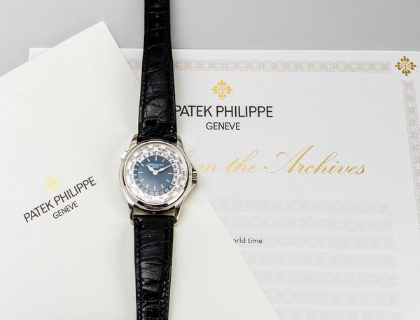 PATEK PHILIPPE : Raffinato ed attraente Worldtime ref 5110P in platino 950, quadrante azzurro con lavorazione circolare Guilloch, disco con 24 fusi orari girevole azionato da pulsante a pressione ad ore 10 accompagnato da Estratto d'Archivio  - Asta Orologi da Polso e da Tasca - Associazione Nazionale - Case d'Asta italiane