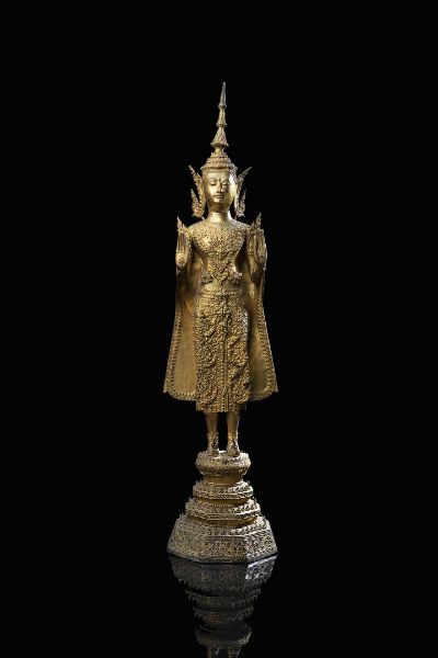 BUDDHA : Figura di Buddha in bronzo dorato nella posizione eretta  Thailandia  XIX secolo. h cm 71 5x18  - Asta Asta di Arte Orientale - Associazione Nazionale - Case d'Asta italiane