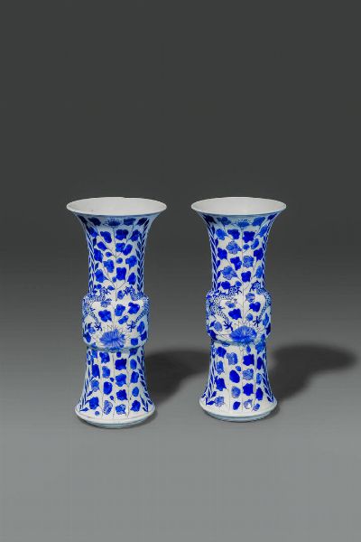 COPPIA DI VASI : Coppia di vasi a tromba in porcellana bianco e blu  dipinti con draghi e fiori  Cina  dinastia Qing  XVIII sec H 25 cm Diam 11 cm  - Asta Asta di Arte Orientale - Associazione Nazionale - Case d'Asta italiane