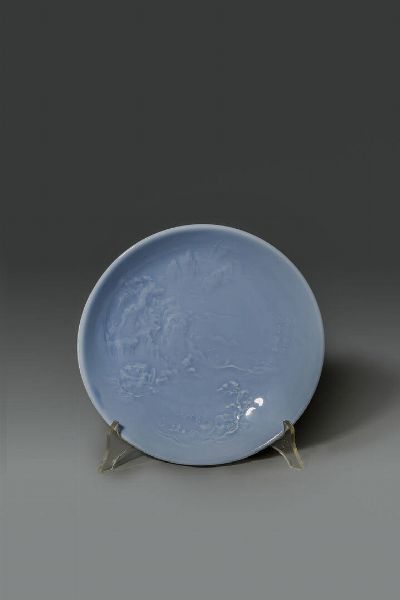 PIATTO : Piatto in porcellana claire de lune decorato con paesaggio a rilievo  Cina  Jingdezhen  XX sec (1960) Diam cm 21 H cm 4  - Asta Asta di Arte Orientale - Associazione Nazionale - Case d'Asta italiane