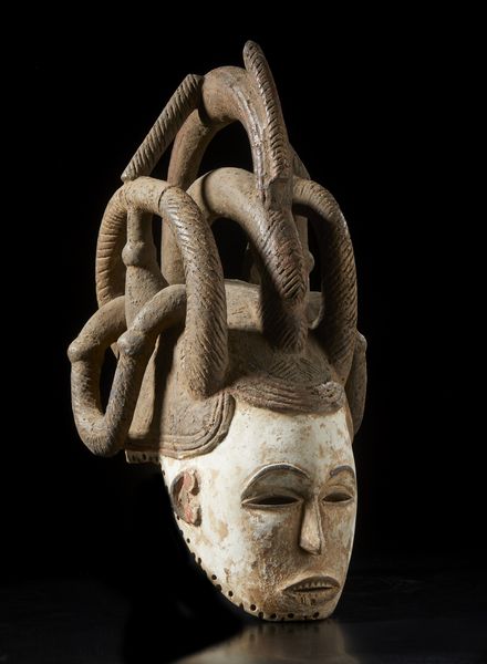 Igbo - Nigeria : Maschera a elmo antropomorfa femminile con elaborata acconciatura. Legno, colino e pigmento.  - Asta Asta 422 | AFRICA, OCEANIA E AMERICHE - ARTIGIANATO AFRICANO: VARI COMMITTENTI E SELEZIONE DALLA COLLEZIONE BARTOLOMUCCI Online - Associazione Nazionale - Case d'Asta italiane