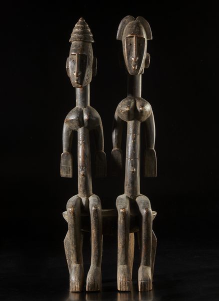 Bambara - Mali : Scultura composta da coppia di figure antropomorfe sedute su seggio, maschile e femminile, caratterizzate da elaborate acconciature e scarificazioni.Legno a patina scura.  - Asta Asta 422 | AFRICA, OCEANIA E AMERICHE - ARTIGIANATO AFRICANO: VARI COMMITTENTI E SELEZIONE DALLA COLLEZIONE BARTOLOMUCCI Online - Associazione Nazionale - Case d'Asta italiane