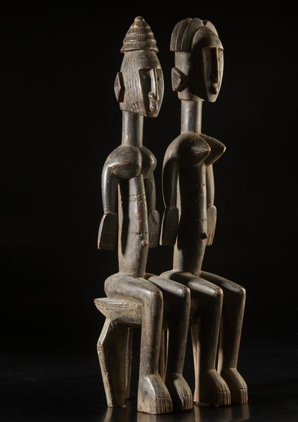 Bambara - Mali : Scultura composta da coppia di figure antropomorfe sedute su seggio, maschile e femminile, caratterizzate da elaborate acconciature e scarificazioni.Legno a patina scura.  - Asta Asta 422 | AFRICA, OCEANIA E AMERICHE - ARTIGIANATO AFRICANO: VARI COMMITTENTI E SELEZIONE DALLA COLLEZIONE BARTOLOMUCCI Online - Associazione Nazionale - Case d'Asta italiane