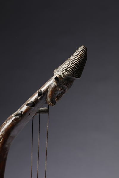 Bambara - Mali : Strumento musicale a corde o arpa, realizzato con cassa armonica in forma di volto antropomorfo.Legno a patina marrone, pelle e corde.  - Asta Asta 422 | AFRICA, OCEANIA E AMERICHE - ARTIGIANATO AFRICANO: VARI COMMITTENTI E SELEZIONE DALLA COLLEZIONE BARTOLOMUCCI Online - Associazione Nazionale - Case d'Asta italiane