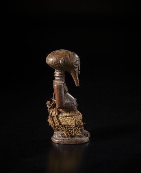 Songye - Repubblica Democratica del Congo : Scultura antropomorfa in forma di feticcio. Legno duro a patina marrone e rafia.  - Asta Asta 422 | AFRICA, OCEANIA E AMERICHE - ARTIGIANATO AFRICANO: VARI COMMITTENTI E SELEZIONE DALLA COLLEZIONE BARTOLOMUCCI Online - Associazione Nazionale - Case d'Asta italiane