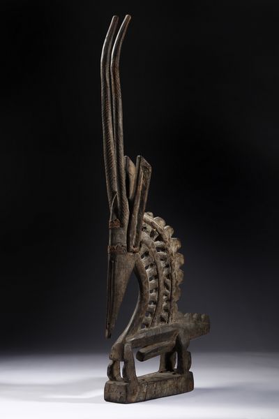 Bambara - Mali : Cimiero da danza o Chiwara a forma di scultura zoomorfa stilizzata  raffigurante un maschio di antilope. Legno duro a patina scura e lamine di metallo.  - Asta Asta 422 | AFRICA, OCEANIA E AMERICHE - ARTIGIANATO AFRICANO: VARI COMMITTENTI E SELEZIONE DALLA COLLEZIONE BARTOLOMUCCI Online - Associazione Nazionale - Case d'Asta italiane