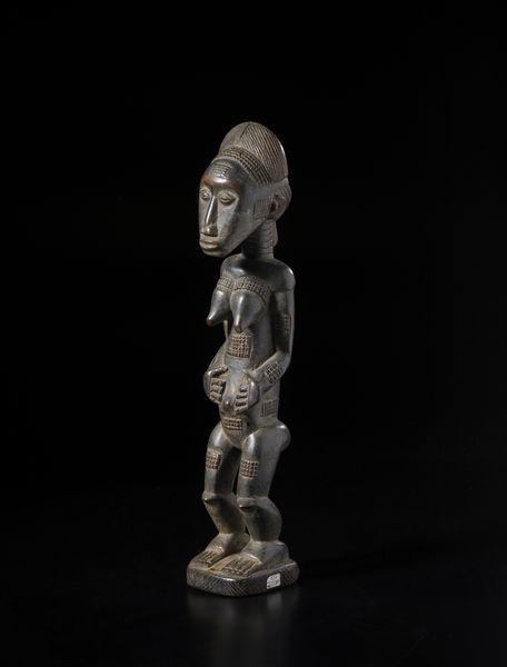 Baule - Costa d'Avorio : Scultura antropomorfa femminile con mani sull'addome.Legno a patina scura.  - Asta Asta 422 | AFRICA, OCEANIA E AMERICHE - ARTIGIANATO AFRICANO: VARI COMMITTENTI E SELEZIONE DALLA COLLEZIONE BARTOLOMUCCI Online - Associazione Nazionale - Case d'Asta italiane