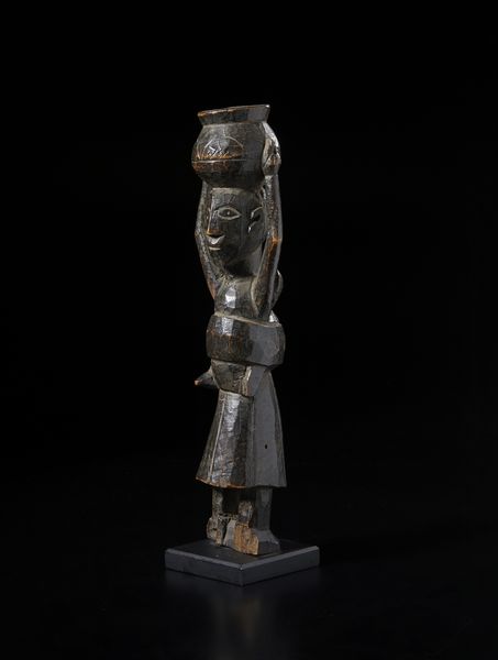 Baule - Costa d'Avorio : Scultura antropomorfa femminile con bambino sul dorso e con vaso sul capo. Legno duro a patina scura.  - Asta Asta 422 | AFRICA, OCEANIA E AMERICHE - ARTIGIANATO AFRICANO: VARI COMMITTENTI E SELEZIONE DALLA COLLEZIONE BARTOLOMUCCI Online - Associazione Nazionale - Case d'Asta italiane