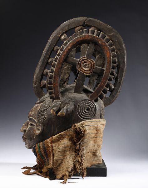 Igbo - Nigeria : Maschera antropomorfa con elaborata acconciatura. Legno a patina scura, pigmenti e tessuti.  - Asta Asta 422 | AFRICA, OCEANIA E AMERICHE - ARTIGIANATO AFRICANO: VARI COMMITTENTI E SELEZIONE DALLA COLLEZIONE BARTOLOMUCCI Online - Associazione Nazionale - Case d'Asta italiane