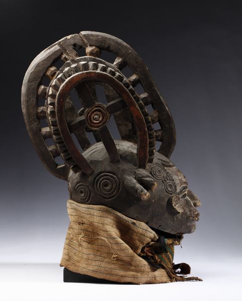 Igbo - Nigeria : Maschera antropomorfa con elaborata acconciatura. Legno a patina scura, pigmenti e tessuti.  - Asta Asta 422 | AFRICA, OCEANIA E AMERICHE - ARTIGIANATO AFRICANO: VARI COMMITTENTI E SELEZIONE DALLA COLLEZIONE BARTOLOMUCCI Online - Associazione Nazionale - Case d'Asta italiane