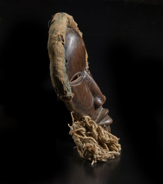 Dan - Costa d'Avorio/Liberia : Maschera antropomorfa. Legno a patina marrone, corda e fibre.  - Asta Asta 422 | AFRICA, OCEANIA E AMERICHE - ARTIGIANATO AFRICANO: VARI COMMITTENTI E SELEZIONE DALLA COLLEZIONE BARTOLOMUCCI Online - Associazione Nazionale - Case d'Asta italiane