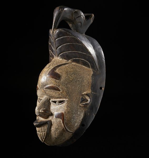 Igbo - Nigeria : Maschera antropomorfa con uccello scolpito nella parte sommitale. Legno e pigmenti.  - Asta Asta 422 | AFRICA, OCEANIA E AMERICHE - ARTIGIANATO AFRICANO: VARI COMMITTENTI E SELEZIONE DALLA COLLEZIONE BARTOLOMUCCI Online - Associazione Nazionale - Case d'Asta italiane