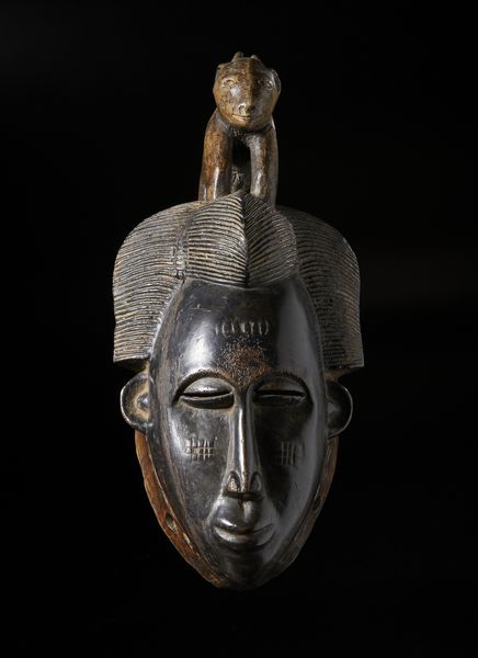 Guro - Costa d'Avorio : Maschera antropomorfa con figura zoomorfa. Legno duro a patina scura e pigmenti.  - Asta Asta 422 | AFRICA, OCEANIA E AMERICHE - ARTIGIANATO AFRICANO: VARI COMMITTENTI E SELEZIONE DALLA COLLEZIONE BARTOLOMUCCI Online - Associazione Nazionale - Case d'Asta italiane