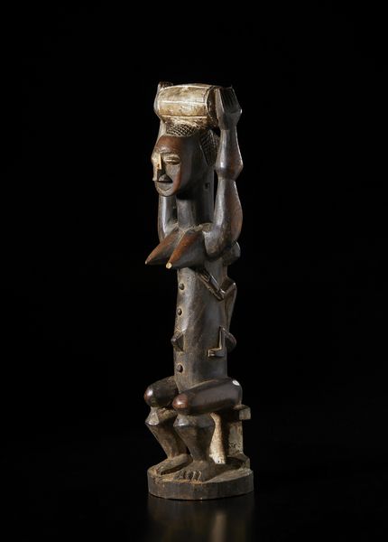 Atti - Costa d'Avorio : Scultura antropomorfa di figura femminile seduta con bambino sulla schiena.Legno a patina scura, caolino e pigmenti.  - Asta Asta 422 | AFRICA, OCEANIA E AMERICHE - ARTIGIANATO AFRICANO: VARI COMMITTENTI E SELEZIONE DALLA COLLEZIONE BARTOLOMUCCI Online - Associazione Nazionale - Case d'Asta italiane