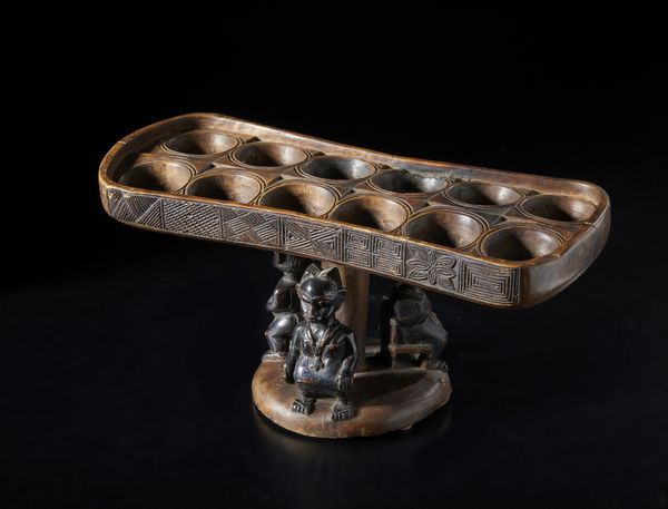 Artigianato africano : Tavola da gioco Wari a dodici buche, con tre figure antropomorfe in forma di cariatidi.Legno e pigmento.  - Asta Asta 422 | AFRICA, OCEANIA E AMERICHE - ARTIGIANATO AFRICANO: VARI COMMITTENTI E SELEZIONE DALLA COLLEZIONE BARTOLOMUCCI Online - Associazione Nazionale - Case d'Asta italiane