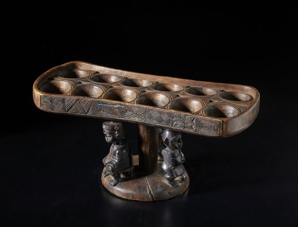 Artigianato africano : Tavola da gioco Wari a dodici buche, con tre figure antropomorfe in forma di cariatidi.Legno e pigmento.  - Asta Asta 422 | AFRICA, OCEANIA E AMERICHE - ARTIGIANATO AFRICANO: VARI COMMITTENTI E SELEZIONE DALLA COLLEZIONE BARTOLOMUCCI Online - Associazione Nazionale - Case d'Asta italiane