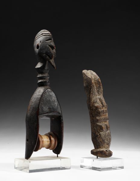 Dogon - Mali : Lotto composto da una puleggia da telaio con testa antropomorfa e da una piccola scultura antropomorfa stilizzata o Nommo, antenato primordiale, in piedi con le braccia alzate. Legno.  - Asta Asta 422 | AFRICA, OCEANIA E AMERICHE - ARTIGIANATO AFRICANO: VARI COMMITTENTI E SELEZIONE DALLA COLLEZIONE BARTOLOMUCCI Online - Associazione Nazionale - Case d'Asta italiane