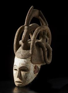 Igbo - Nigeria : Maschera a elmo antropomorfa femminile con elaborata acconciatura. Legno, colino e pigmento.  - Asta Asta 422 | AFRICA, OCEANIA E AMERICHE - ARTIGIANATO AFRICANO: VARI COMMITTENTI E SELEZIONE DALLA COLLEZIONE BARTOLOMUCCI Online - Associazione Nazionale - Case d'Asta italiane