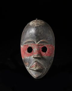 Dan - Costa d'Avorio/Liberia - Maschera antropomorfa. Legno a patina scura, tessuto, osso e metallo.