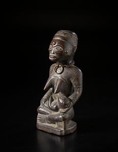 Kongo - Repubblica Democratica del Congo : Scultura antropomorfa in forma di maternit Legno duro a patina scura, fibre e metallo.  - Asta Asta 422 | AFRICA, OCEANIA E AMERICHE - ARTIGIANATO AFRICANO: VARI COMMITTENTI E SELEZIONE DALLA COLLEZIONE BARTOLOMUCCI Online - Associazione Nazionale - Case d'Asta italiane