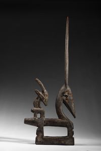 Bambara - Mali : Cimiero da danza  o Chiwara  a forma  di scultura zoomorfa  raffigurante un'antilope stilizzata con il suo piccolo in piedi sulla schiena.Legno duro a patina scura, metallo e tessuto.  - Asta Asta 422 | AFRICA, OCEANIA E AMERICHE - ARTIGIANATO AFRICANO: VARI COMMITTENTI E SELEZIONE DALLA COLLEZIONE BARTOLOMUCCI Online - Associazione Nazionale - Case d'Asta italiane