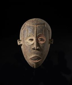 Igbo - Nigeria - Maschera antropomorfa. Legno a patina bruna, caolino e tracce di pigmenti.