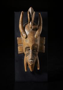 Senufo - Costa d'Avorio/Mali/Burkina Faso - Piccola maschera antropozoomorfa KpelieLegno duro a patina chiara.