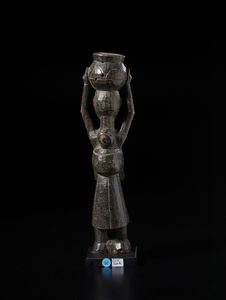 Baule - Costa d'Avorio : Scultura antropomorfa femminile con bambino sul dorso e con vaso sul capo. Legno duro a patina scura.  - Asta Asta 422 | AFRICA, OCEANIA E AMERICHE - ARTIGIANATO AFRICANO: VARI COMMITTENTI E SELEZIONE DALLA COLLEZIONE BARTOLOMUCCI Online - Associazione Nazionale - Case d'Asta italiane