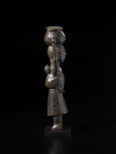 Baule - Costa d'Avorio : Scultura antropomorfa femminile con bambino sul dorso e con vaso sul capo. Legno duro a patina scura.  - Asta Asta 422 | AFRICA, OCEANIA E AMERICHE - ARTIGIANATO AFRICANO: VARI COMMITTENTI E SELEZIONE DALLA COLLEZIONE BARTOLOMUCCI Online - Associazione Nazionale - Case d'Asta italiane